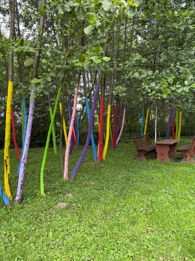 Grădina mare cu pomii colorați și hamac